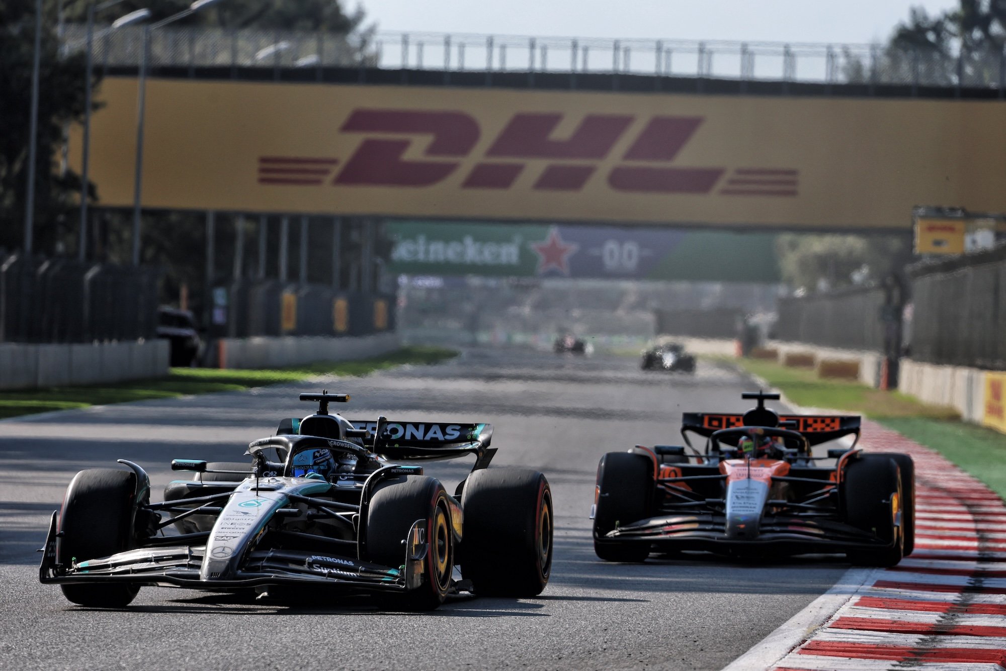 George Russell (GBR) Mercedes AMG F1 W16 and Oscar Piastri (AUS) McLaren MCL39 battle for position.