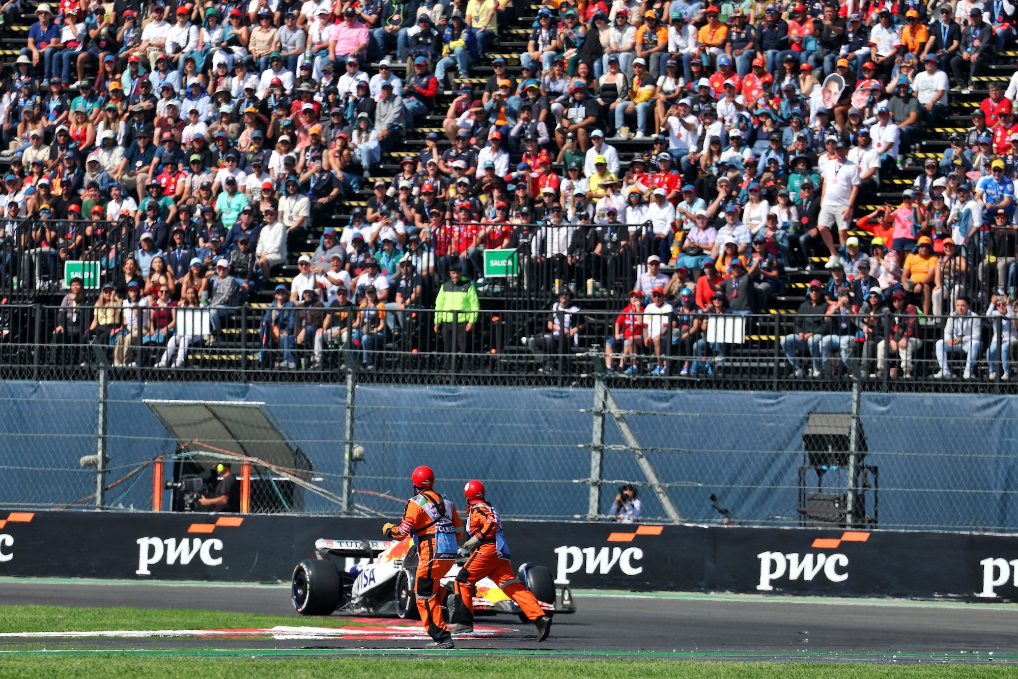 F1: Steiner comenta decisão de acionar VSC no GP do México Marshals remove debris from the circuit as Liam Lawson (NZL) Racing Bulls VCARB 02 approaches.